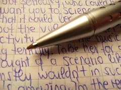 Metallic ballpen tips / biro Ballpen Ballpoint pen in silver with handwritten random blue text on quad-ruled paper